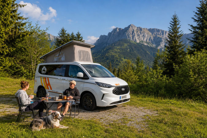 Couple avec chien en van VAN-IT au cœur des montagnes près d’Annecy