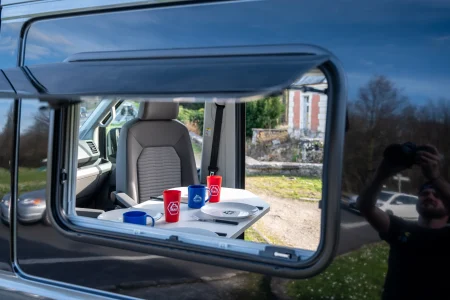Coin repas avec table et sièges pivotants dans le Volkswagen Grand California.