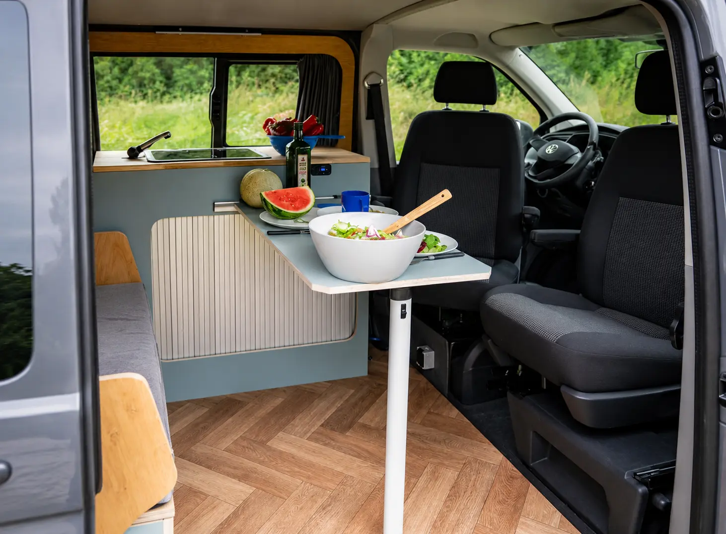 Espace repas du van aménagé Venturo VAN-IT avec table, banquette et sièges avant