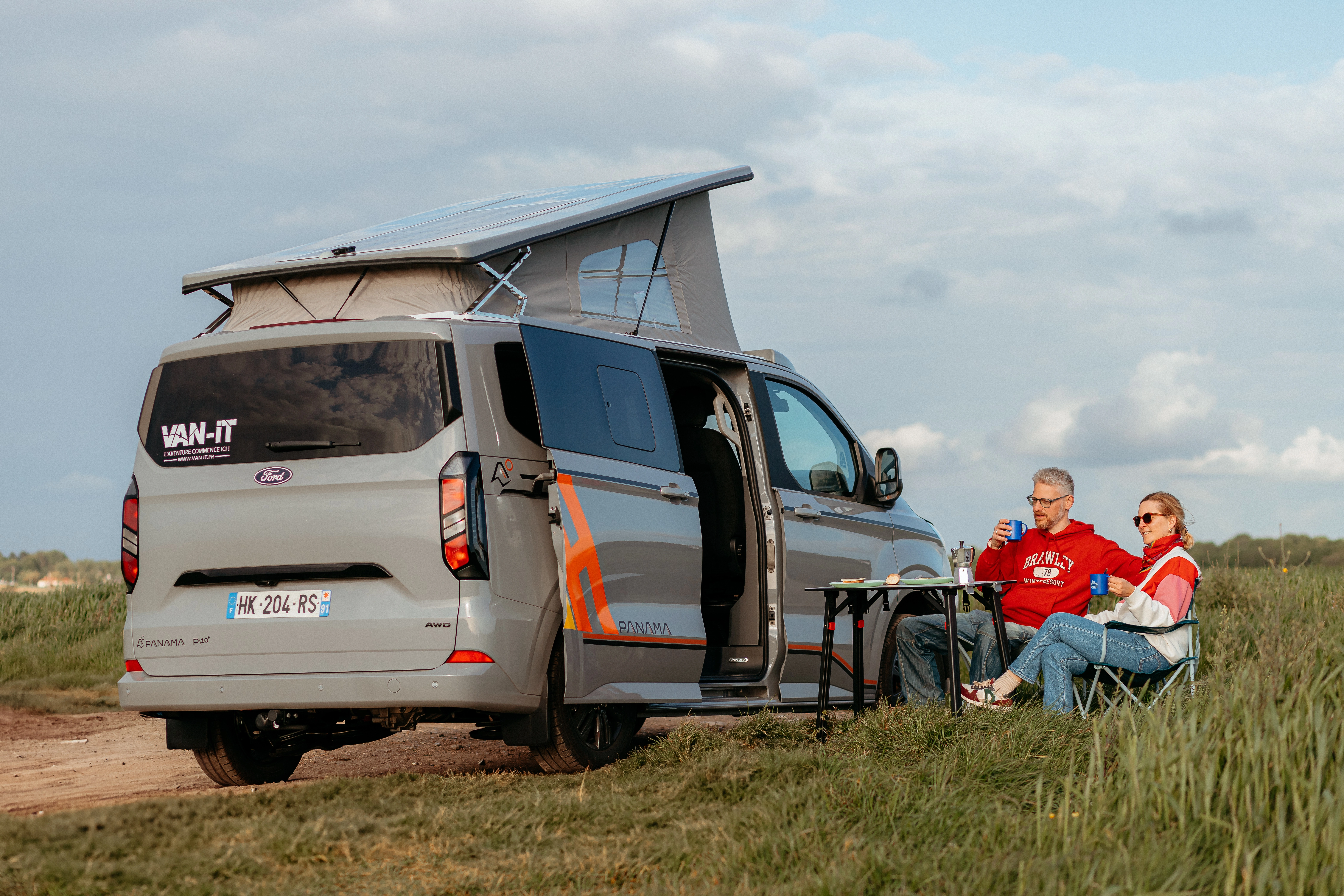 Van aménagé Panama VAN-IT avec toit relevable et famille installée face au paysage